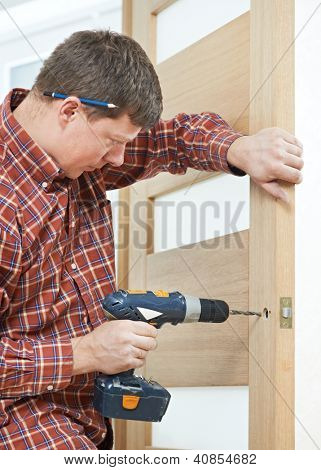Mandlige handyman Tømrer på interiør træ dør lås installation