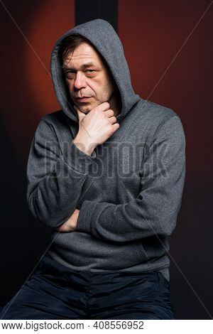Studio Portrait Of A 40-50-year-old Serious Man In A Gray Hoodie On A Neutral Background, Eyes Direc