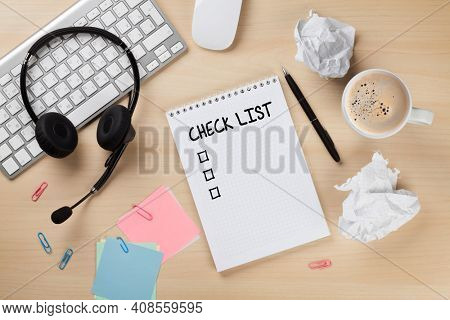 Office desk with headset, notepad with check list and pc. Call center support table. Top veiw flat lay