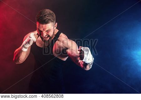 Bearded Tattooed Portsman Muay Thai Boxer In Black Undershirt And Boxing Gloves Fighting On Dark Bac