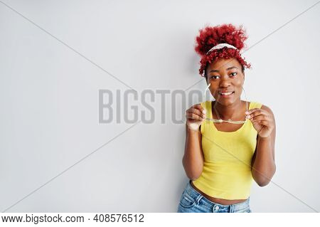 African American Woman In Yellow Singlet And Eyglasses Against White Wall.