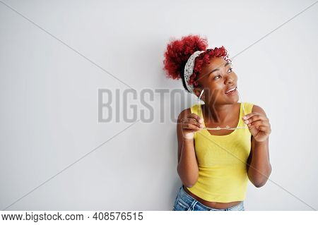 African American Woman In Yellow Singlet And Eyglasses Against White Wall.