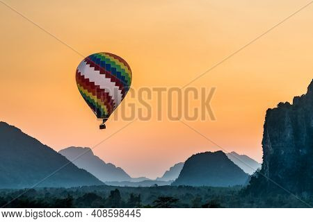 Colorful Hot Air Ball Floats Through The Misty Morning Mountain Range Of Vang Viang In Loas Asia