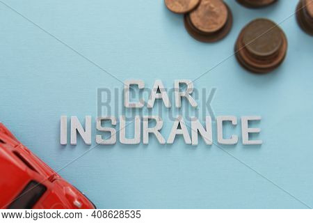 Car Insurance Words Red Car Model And Coins Over Blue Background