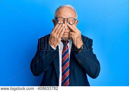Senior caucasian man wearing business suit and tie rubbing eyes for fatigue and headache, sleepy and tired expression. vision problem 