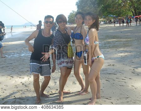 Asian Husband And Wife With Their Twin Teenage Daughters Are On Beach Vacation. Young Happy Women In