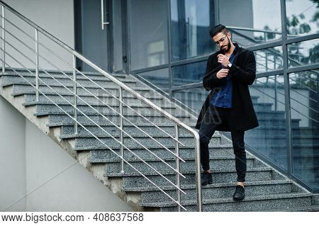 Middle Eastern Entrepreneur Wear Black Coat And Blue Shirt, Eyeglasses Against Office Building, Stan
