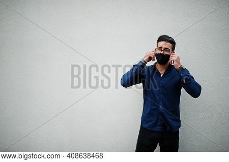 Middle Eastern Entrepreneur Wear Black Face Mask And Eyeglasses Against White Wall. New Normal Life