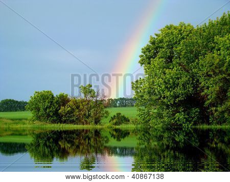 In summer day the beautiful rainbow fell for the small river