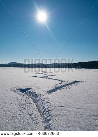 Deep Footprints Of Ice Skaters In Fresh Snow. Skating On An Open Lake During Amazing Sunny Day