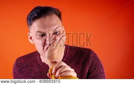 Man Getting Slapped On Orange Background. Unhappy Scared Man Getting Slapped Standing On Orange Back