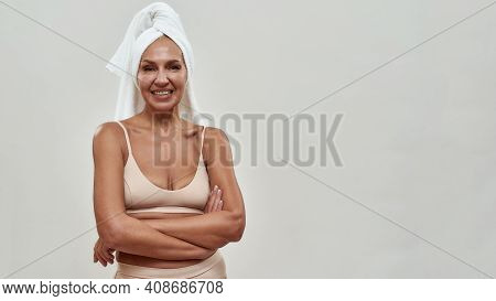 Female Folding Arms In Front Of Her Stomach And Grinning While Having A White Towel On The Head. Cop