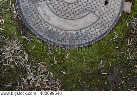 Green Moss And Old Manhole. Grunge Background.