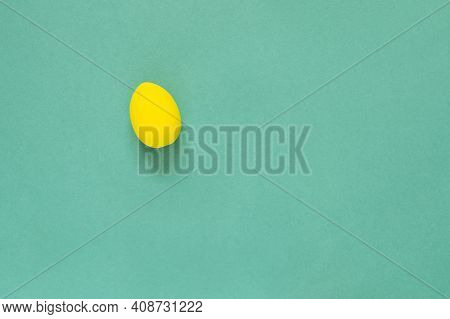 One Colored Yellow Painted Egg On Green Background Easter Card With Empty Space For Text. Happy East