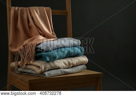 Stack Of Cashmere Clothes On Wooden Chair