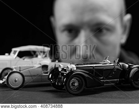 Portrait Of A Collector Of Retro Car Models On A Black Background