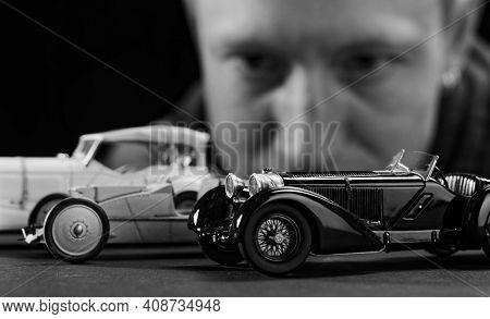 Portrait Of A Collector Of Retro Car Models On A Black Background