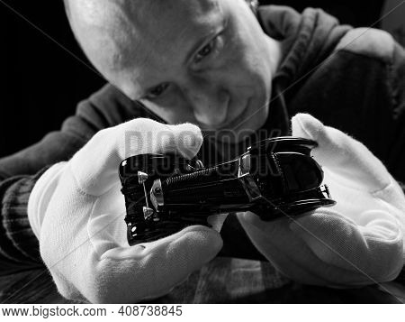 Portrait Of A Collector Of Retro Car Models On A Black Background