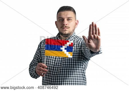 White Guy Holding A Flag Of Nagorno-karabakh Republic And With A Serious Face Shows A Hand Stop Sign