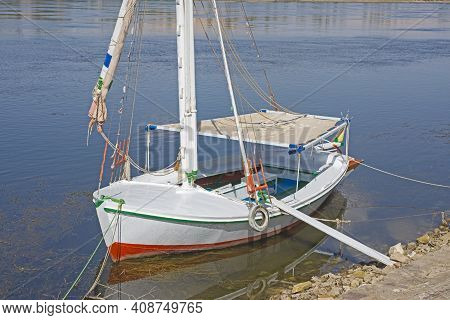 Traditional Wooden Felluca Sailing Boat Moored On Tropical River Bank With Gang Plank