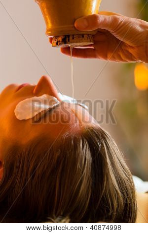 Woman enjoying a Ayurveda oil massage treatment in a spa