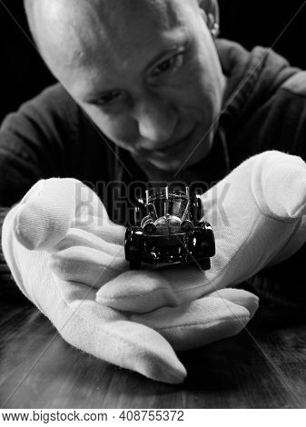 Gomel, Belarus - February 16, 2021: Portrait Of A Collector Of Retro Car Models On A Black Backgroun
