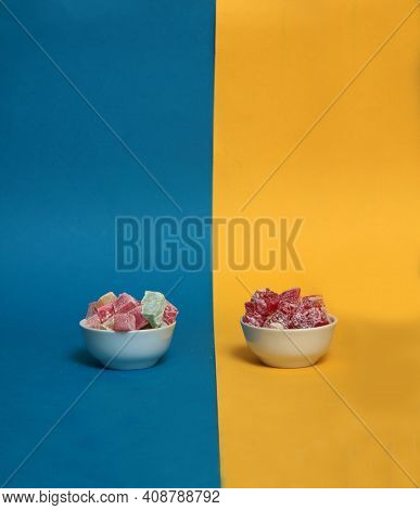 Two Bowls Of Rahat Lakoum Isolated On Blue And Yellow Background. Turkish Sweet Concept. Image Conta