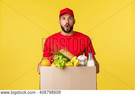 Online Delivery, Shopping And Food Order Concept. Impressed Bearded Courier In Red Uniform Cap, T-sh