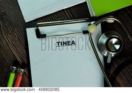 Tinea Write On A Paperwork Isolated On Wooden Table. Medical Or Healthcare Concept