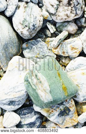 Colored River Stones Of Various Sizes Selective Focus On Greenstone.