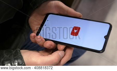 Maikop, Adygea Republic, Russia - February 15, 2021: A Smartphone In Men's Hands On A White Screen O
