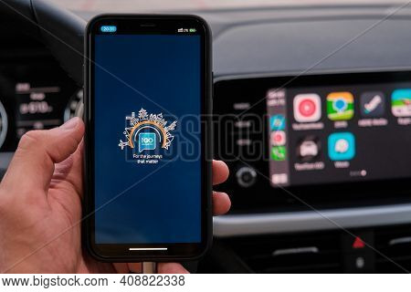 Igo Logo On The Screen Of Smart Phone In Mans Hand On The Background Of Car Dashboard Screen With Ap