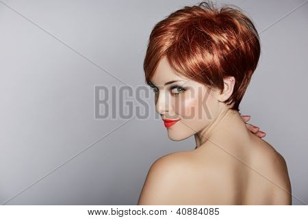 beautiful young woman with red hair wearing short pixie crop hairstyle on studio background