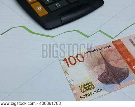 Norwegian Banknote And Calculator On Background With Rising Trend Green Line