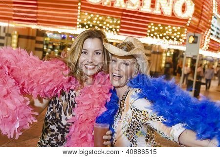 Porträt von zwei Frauen tragen Feather Boas vor Casino-Gebäude