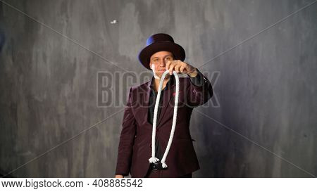 Consummate Mastery Of Magician. The Magician Shows A Trick With A Rope.