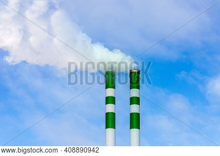 Two Industrial Smoke Pipes From Chimney On Blue Cloudy Sky.white Smoke Emanates From The Pipes.