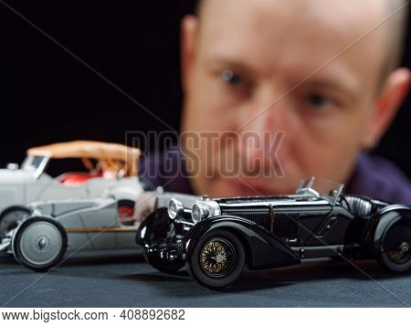 Gomel, Belarus - February 16, 2021: Portrait Of A Collector Of Retro Car Models On A Black Backgroun