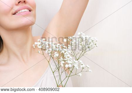 Young Woman Holding Her Hands Up And Showing Armpits With Gypsophila In Her Hand, Armpits Smooth Tra