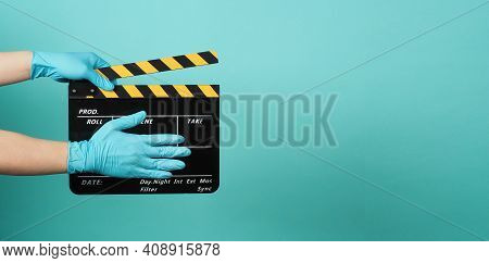 Hand Wear Madical Gloves Or Blue Latex Gloves And Hold Black Clapper Board Or Movie Slate . It Use I