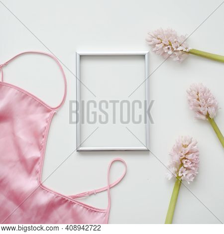 Styled Feminine Flat Lay With Blank Photo Frame, Silk Lingerie And Pink Flowers On White Background.