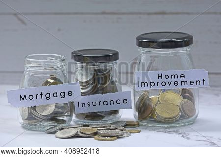 Glass Jars With Multicurrency Coins And Text - Mortgage, Insurance, Home Improvement