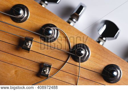 Guitar Fretboard With Tuning Pegs And Strings On A Gray Background. Close-up