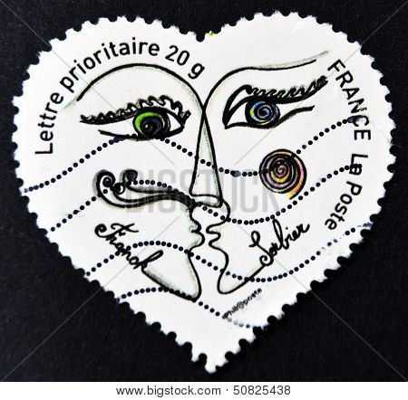 A stamp printed in France shows two people kissing in a heart by Franck Sorbier