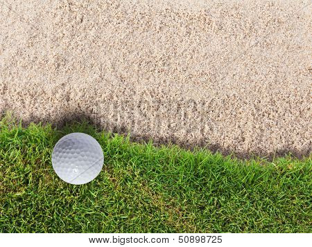 Golf Ball On Green Grass Near Sand Bunker