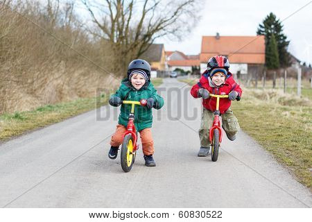 Two Little Twin Toddler Boys Having Fun On Bicycles, Outdoors