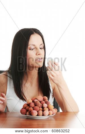 Young beautiful caucasian woman eating litchi fruits, isolated on whiet background