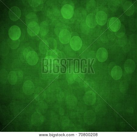 Abstract textured green or Christmas  background with bright circular shapes and a darker vignette border