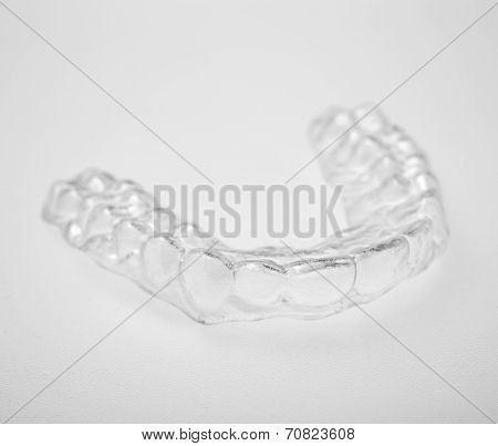 Translucent essix retainer on a gray background