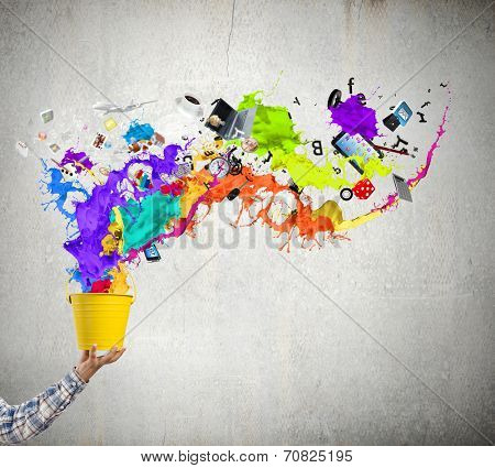 Close up of hand splashing colorful paint from bucket